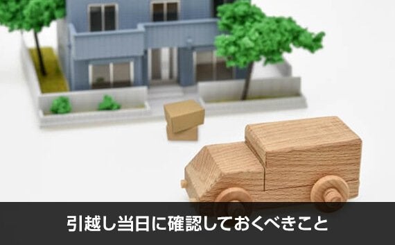 ミニチュアの家の前に置かれているダンボールと木でできたトラック