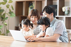 パソコンを見ている家族の写真