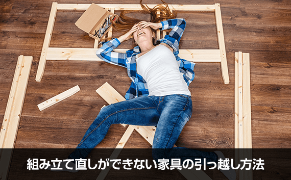 写真：組み立て直しができない家具の引っ越し方法。木材のパーツの上に寝転がっている女性の写真。