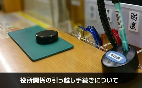 写真：役所関係の引っ越し手続きについて。印鑑が置いてある机の写真。