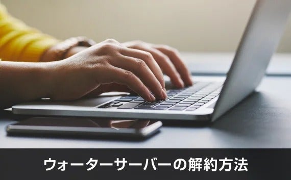 写真:ウォーターサーバーの解約方法。パソコンのキーボードを触っている手。