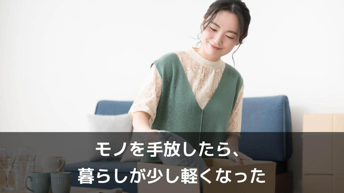 写真：モノを手放したら、暮らしが少し軽くなった。引っ越しの準備で段ボールに荷物を詰める笑顔の若い女性。