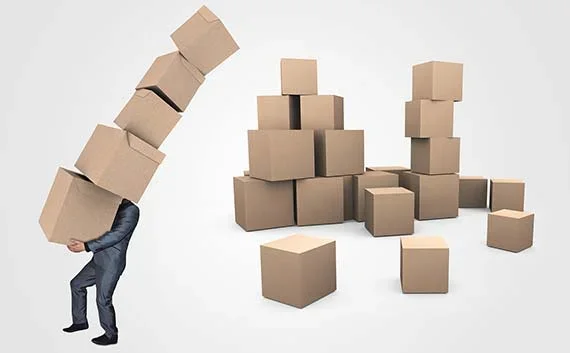 写真：引越しする荷物を少なくして料金を抑える。積まれたダンボールとそれを運ぶ人の写真。