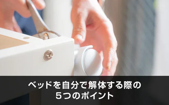 写真：ベッドを自分で解体する際の5つのポイント。ベッドフレームのねじを外している写真。