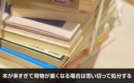 写真：本が多すぎて荷物が重くなる場合は思い切って処分する。積み重なった本のアップの写真。