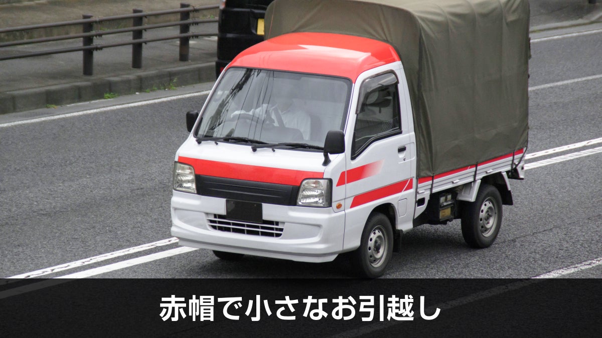 道路を走っている赤帽のトラック