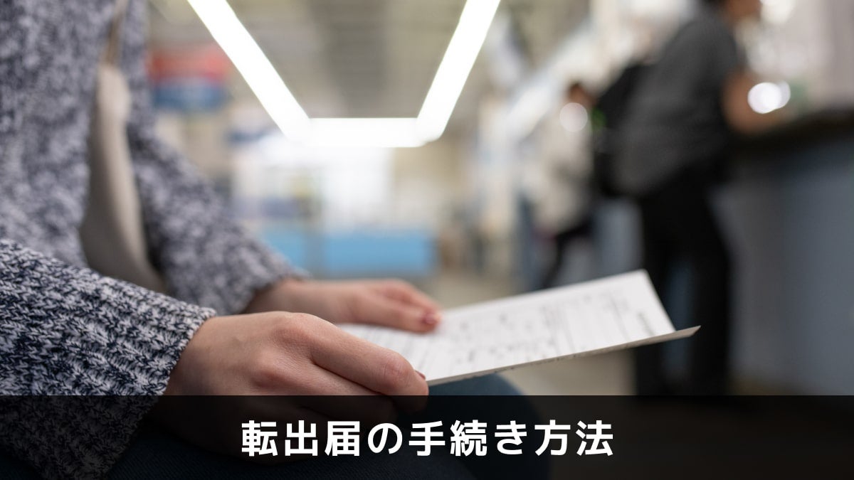 写真：転出届の手続き方法。書類を持った人が座っている写真。