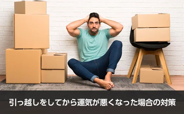 写真：引っ越しをしてから運気が悪くなった場合の対策。ダンボールに囲まれて座っている男性が頭を抱えている写真。