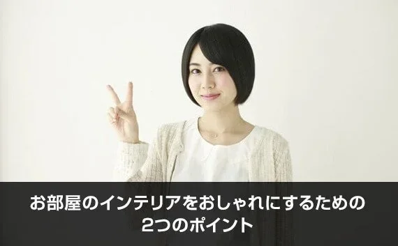 写真：お部屋のインテリアをおしゃれにするための2つのポイント。ピースで2を作っている女性の写真。