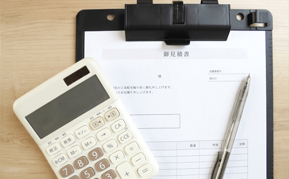 写真：自動車の輸送・陸送業者に見積もりをする際の注意点。見積書と電卓とペン。