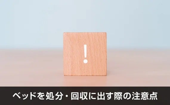 写真：ベッドを処分・回収に出す際の注意点。びっくりマークがかかれた木のオブジェが写っている写真。