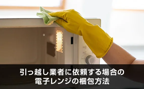 写真：引っ越し業者に依頼する場合の電子レンジの梱包方法。電子レンジを拭いている写真。