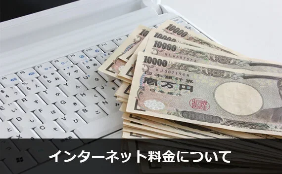 写真:インターネット料金について。札束とノートPCのキーボード部分が写っている写真。