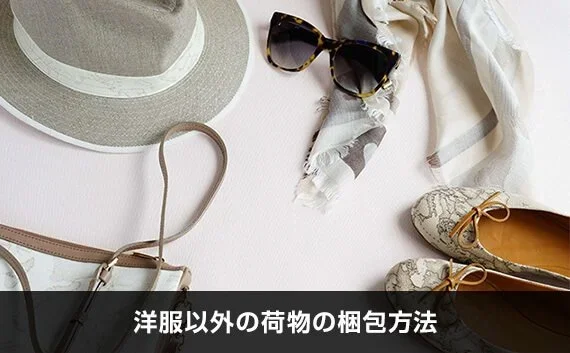 写真：洋服以外の荷物の梱包方法。帽子・めがね・靴・小物が写っている写真。