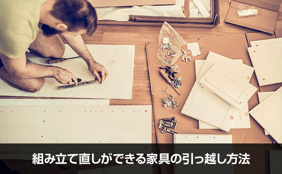 写真：組み立て直しができる家具の引っ越し方法。木材に印をつけている男性の写真。