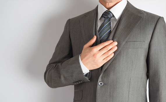 写真：車・バイク輸送の専門業者に依頼する。スーツを着た男性が胸に手を置いている。