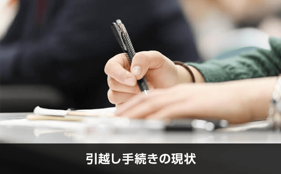 写真：引越し手続きの現状。ペンを持っている写真。