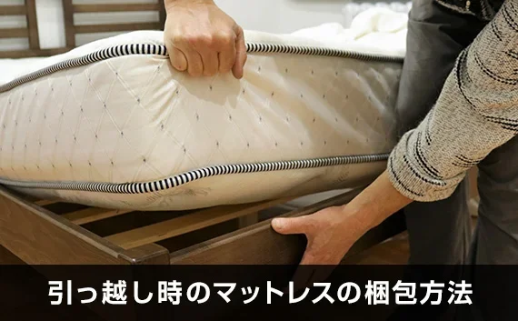 写真：引っ越し時のマットレスの梱包方法。マットレスを掴んでいる写真。
