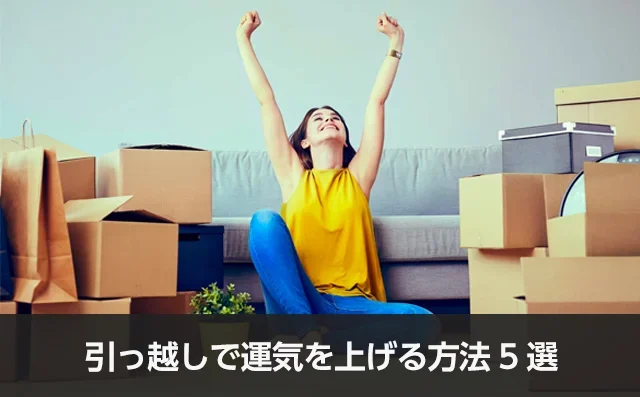 写真：引っ越しで運気を上げる方法5選。ダンボールに囲まれて座っている女性が腕を伸ばしている写真。