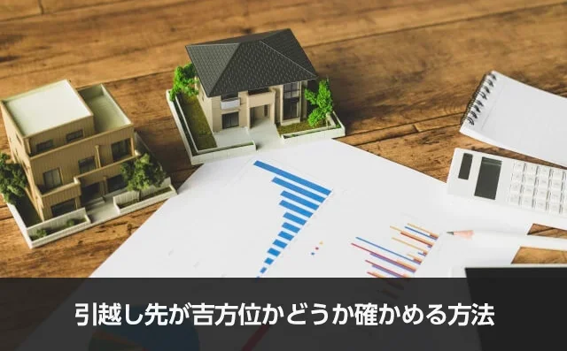 写真：引越し先が吉方位かどうか確かめる方法。手のひらサイズの一軒家のオブジェが2個と書類と電卓が写っている写真。