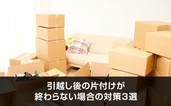 写真：引越し後の片付けが終わらない場合の対策3選。ソファーの前に積み上げられた段ボール。