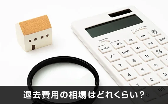 写真：退去費用の相場はどれくらい？。電卓と小さい家のオブジェが写っている写真。
