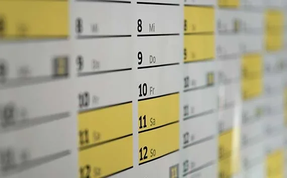 写真：引越し料金の安い時期や日時を選ぶ。アップのカレンダーが写っている写真。