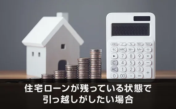 写真：住宅ローンが残っている状態で引っ越しがしたい場合。家のオブジェと電卓と小銭が写っている写真。