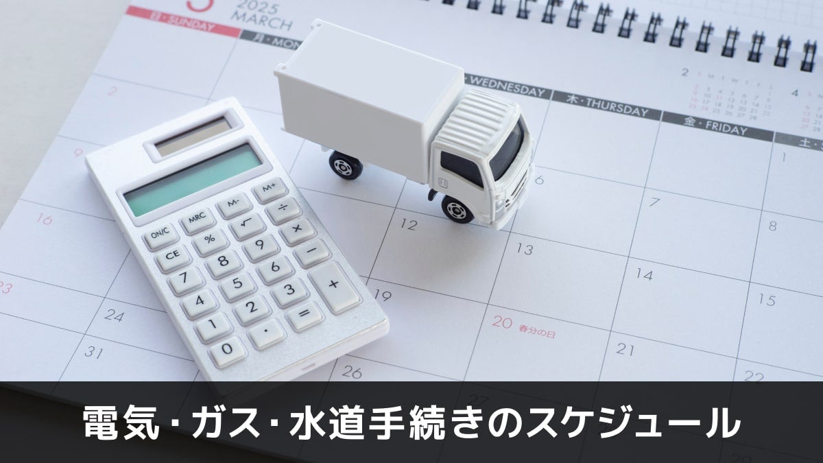 写真:電気・ガス・水道手続きのスケジュール。カレンダーと電卓とトラックのオブジェの写真。