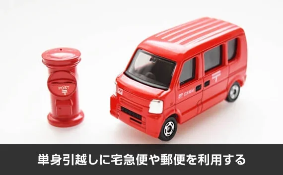 写真：単身引越しに宅急便や郵便を利用する。赤い郵便ポストとトラックのオブジェが写っている写真。