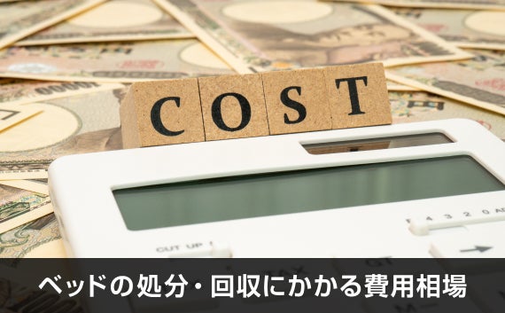 写真：ベッドの処分・回収にかかる費用相場。電卓とお札とcostと書かれた木のオブジェがある写真。