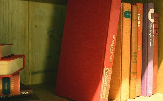 緑色の本棚に無造作に片付けられている洋書