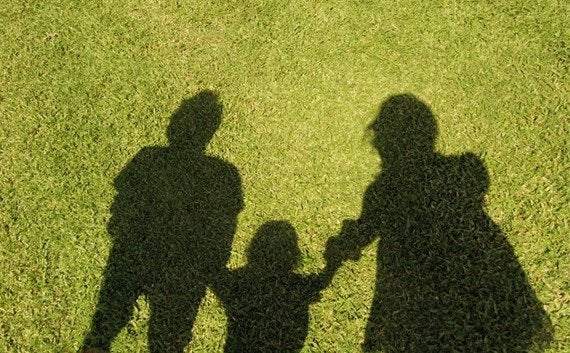 芝生の上に落ちた親子3人家族の影