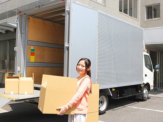 手配したトラックに荷物を搬入する女性
