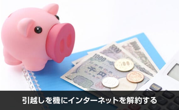 青いノートの上に置かれた豚の貯金箱とお金と電卓