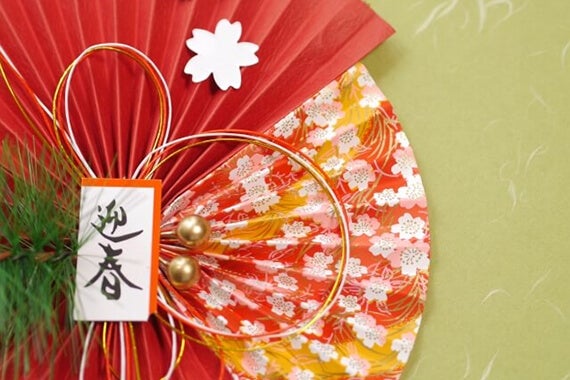 和紙風の柄の上に置かれた、鮮やかな正月飾り